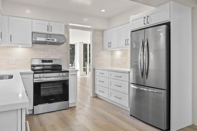 a kitchen with stainless steel appliances a refrigerator stove and microwave