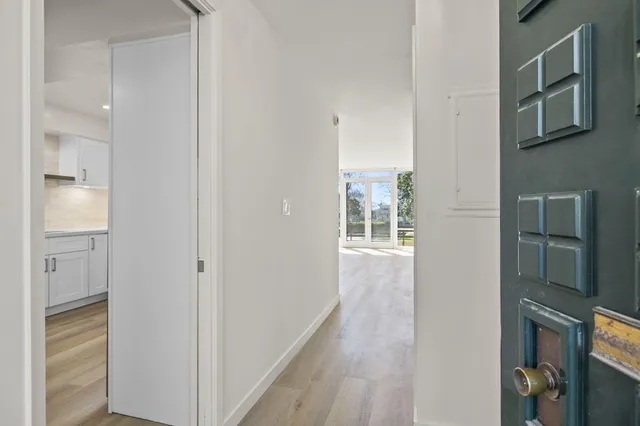 a view of a hallway with wooden floor and entryway
