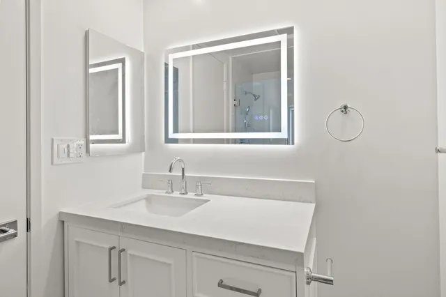 a bathroom with a sink vanity and mirror
