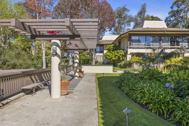 a view of a house with a small yard and lawn chairs