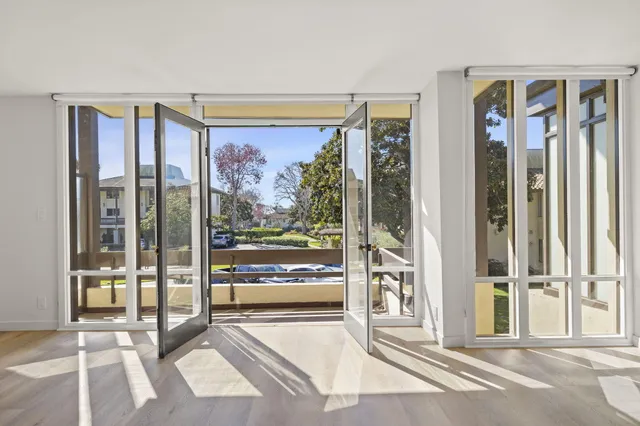 a bedroom with a large window and a glass door