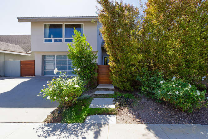 a front view of a house with a yard and trees