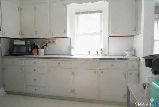 a bedroom with a bed a chair and painting on the wall