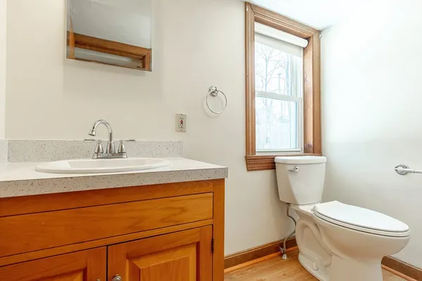 a bathroom with a sink a toilet and a window