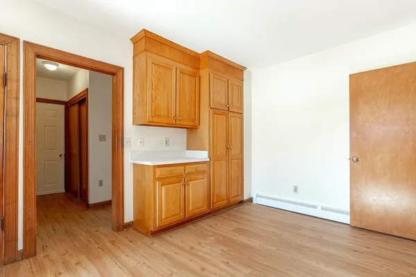 a view of a kitchen with wooden floor and cabinets