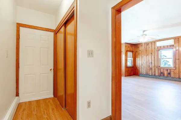 a view of hallway with bathroom and wooden floor