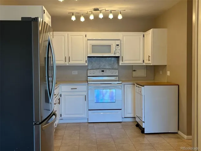 a kitchen with a refrigerator and a stove