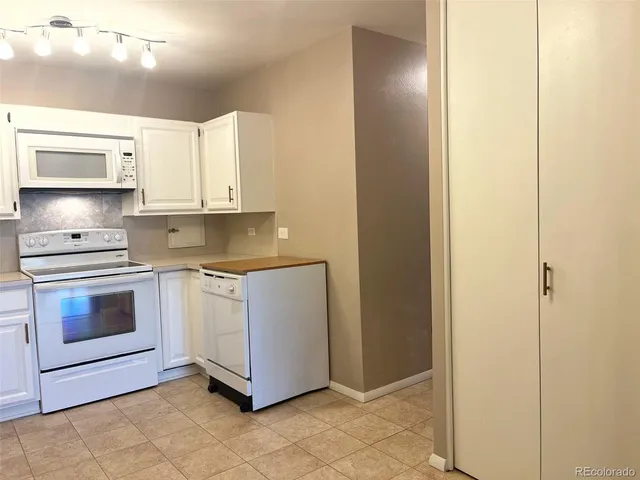 a kitchen with granite countertop white cabinets and stainless steel appliances