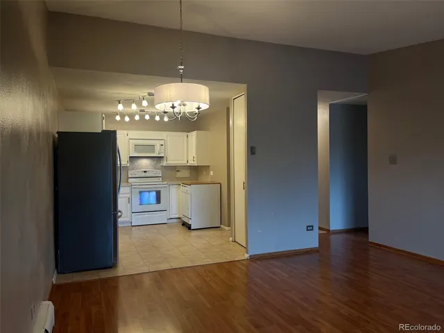a view of a room with wooden floor and chandelier