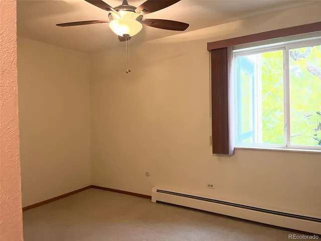 an empty room with a window and a ceiling fan