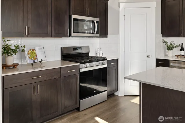 a kitchen with stainless steel appliances a stove microwave and cabinets