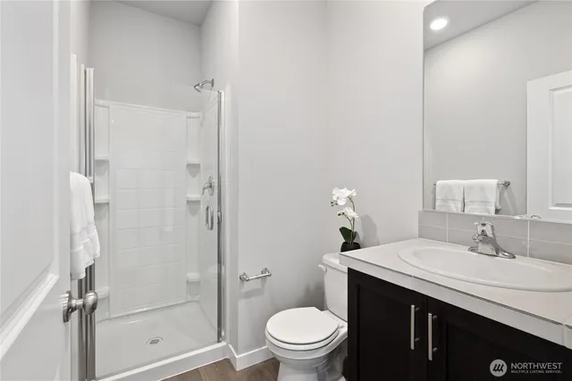 a bathroom with a sink a toilet and shower