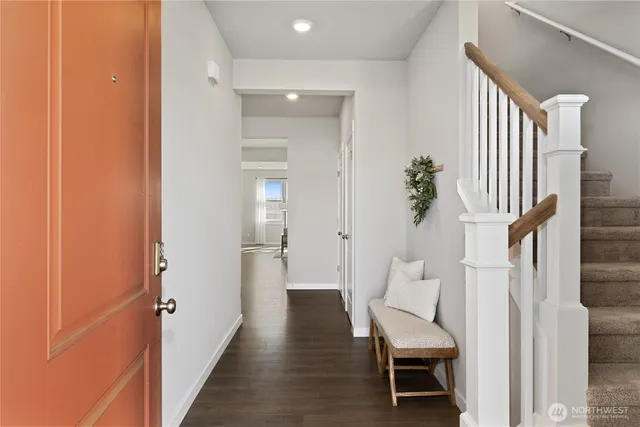 a view of a hallway with wooden floor and furniture