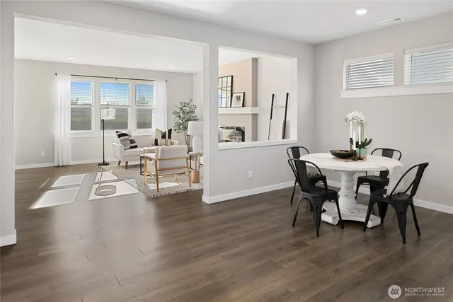 a dining room with wooden floor a chandelier a wooden table and chairs