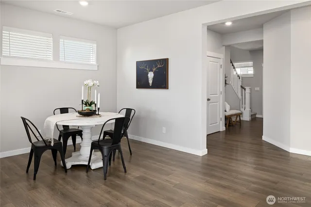 a dining room with furniture and wooden floor