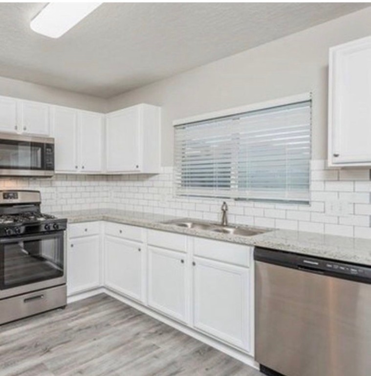 3646 Clipper Winds Way Houston, TX 77084 - Photo 4 of 8 a kitchen with stainless steel appliances granite countertop a sink a stove and cabinets