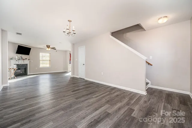 a view of empty room with wooden floor and window