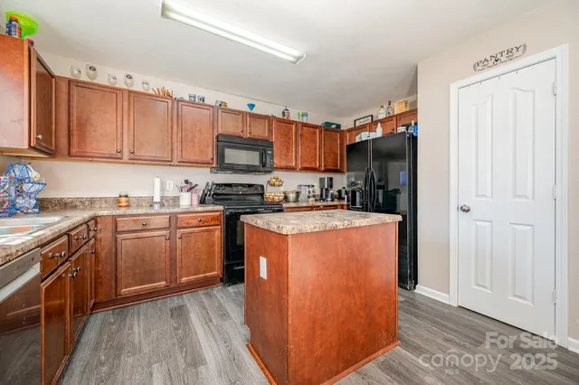 a kitchen with stainless steel appliances granite countertop a refrigerator a sink dishwasher a stove with wooden cabinets and a stove