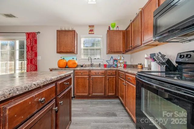 a kitchen with stainless steel appliances granite countertop a sink stove and cabinets