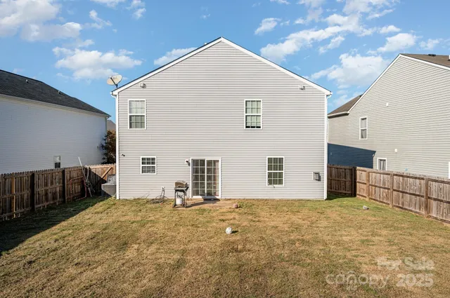 a view of house with backyard and sitting area