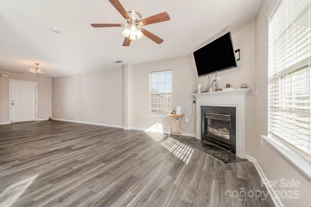 a view of empty room with fireplace and wooden floor