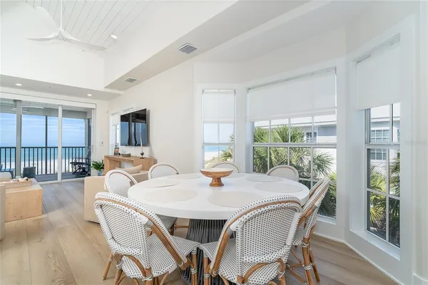a dining room with furniture a chandelier and wooden floor