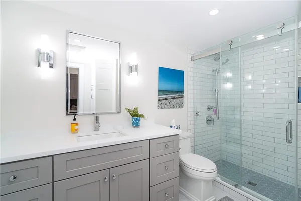 a bathroom with a sink a toilet and shower