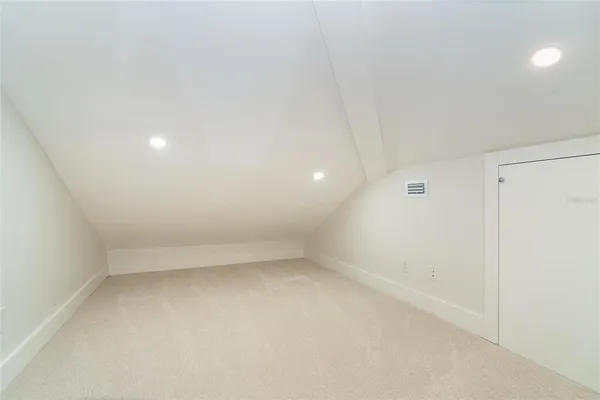 a bedroom with a bed and lamp with wooden floor