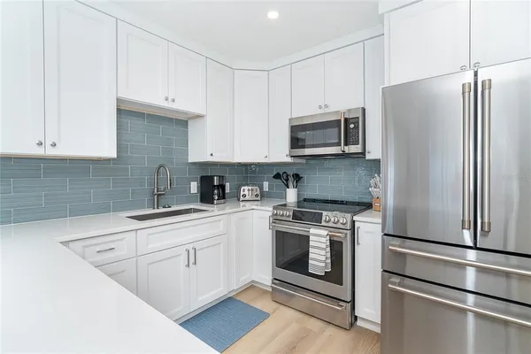 a kitchen with cabinets stainless steel appliances and a sink