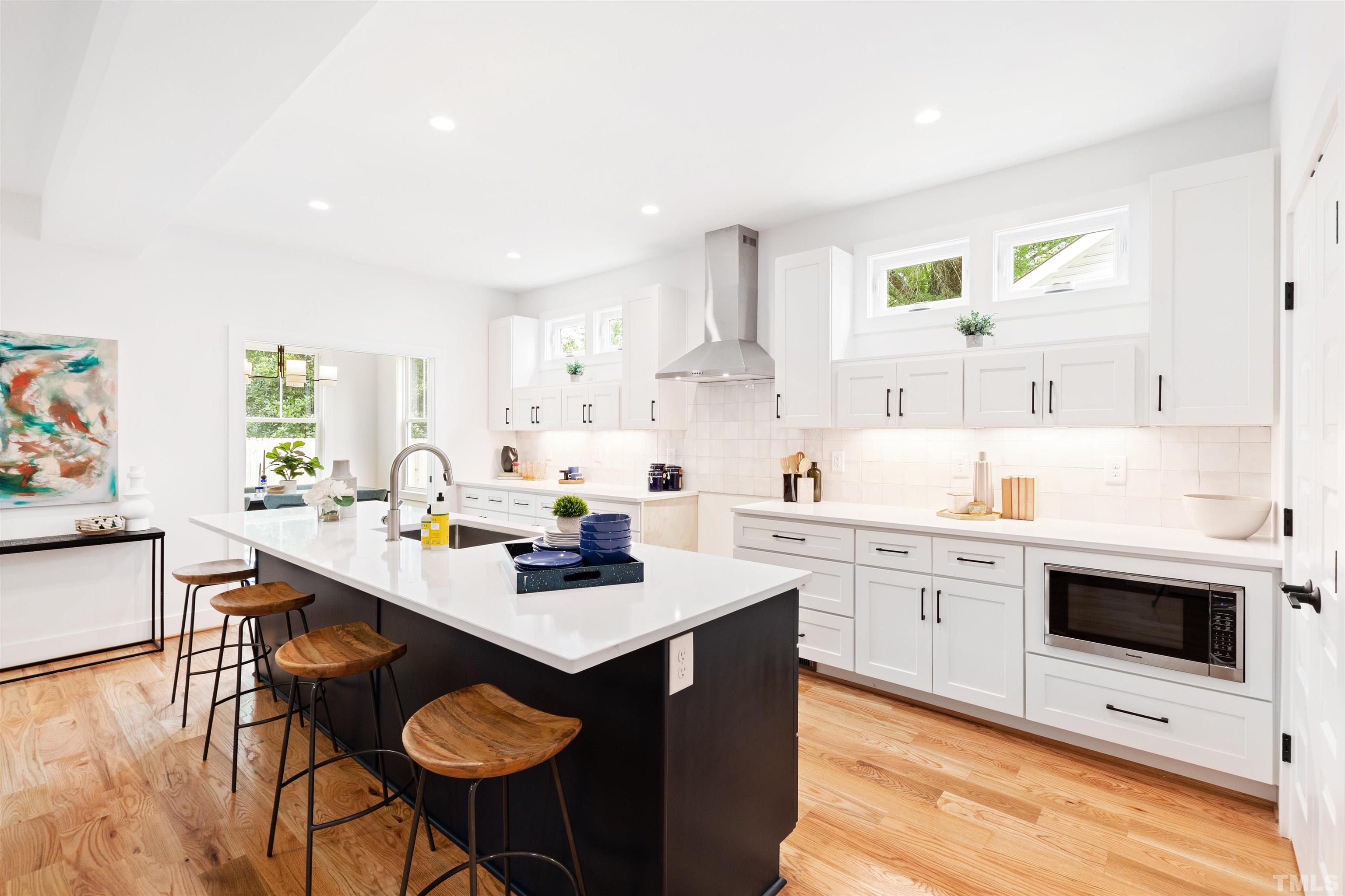 704 Colonial Street Durham, NC 27701 - Photo 11 of 42 a kitchen with stainless steel appliances a sink a stove a refrigerator cabinets and dining table