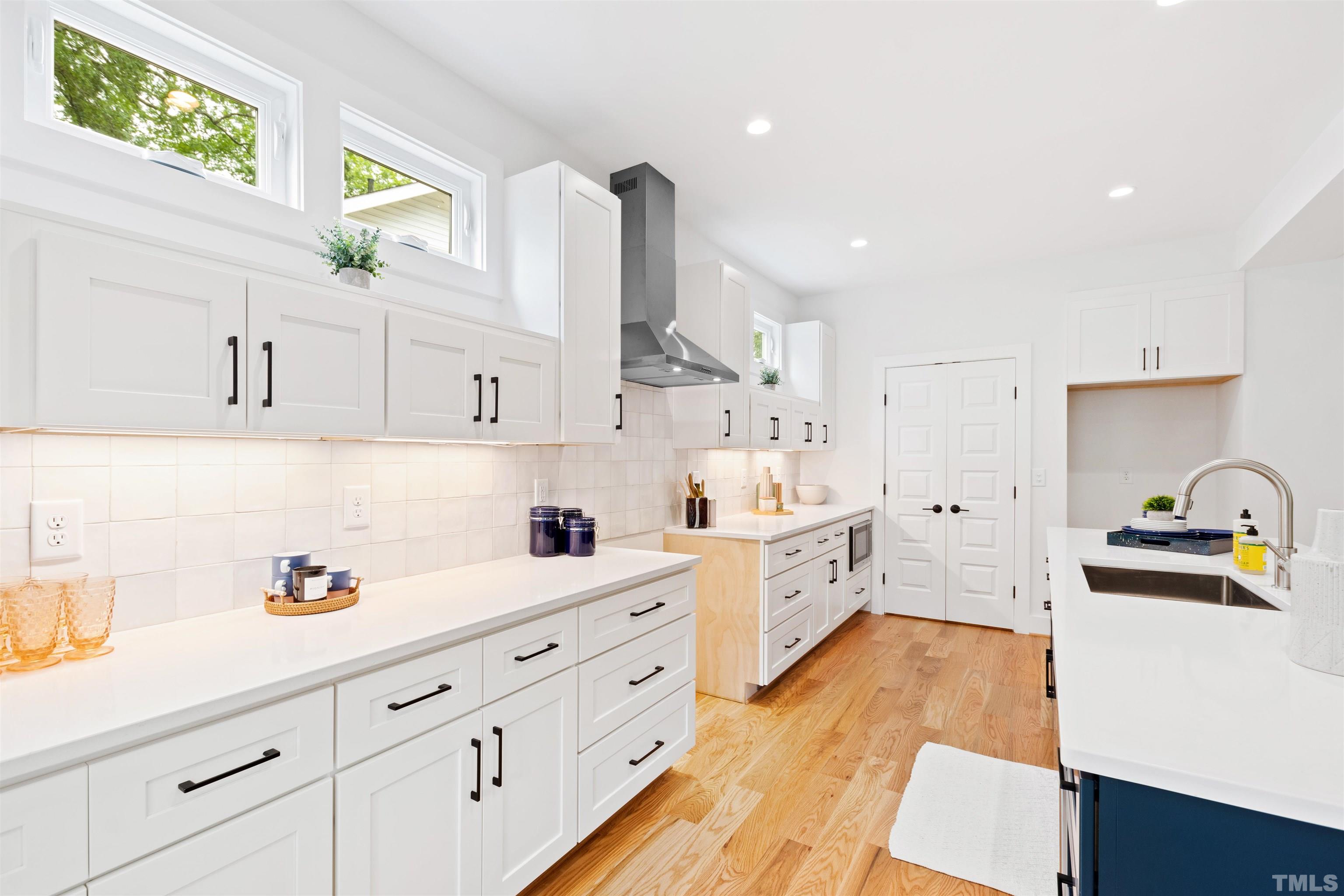 704 Colonial Street Durham, NC 27701 - Photo 14 of 42 a kitchen with cabinets wooden floor and stainless steel appliances