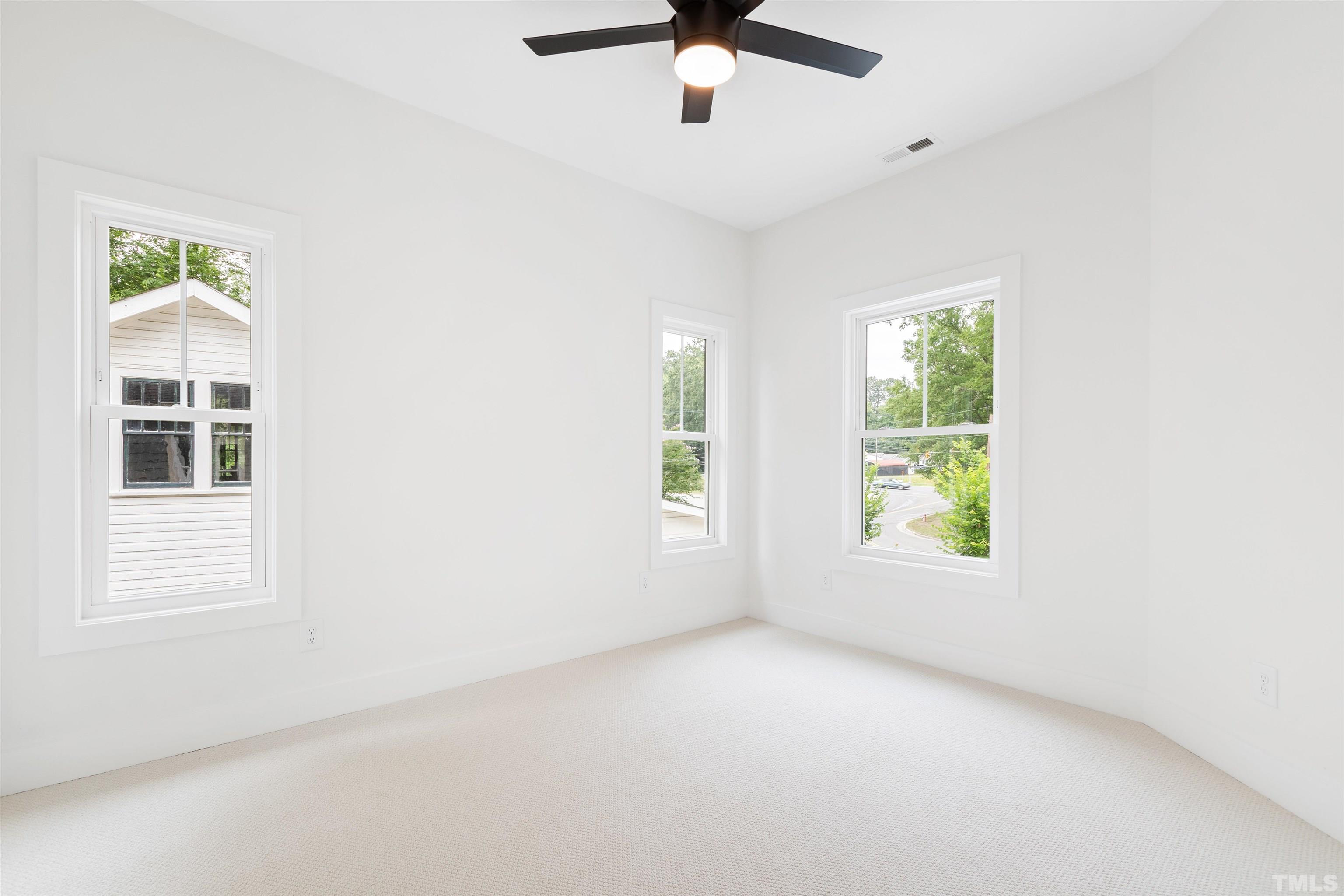 704 Colonial Street Durham, NC 27701 - Photo 36 of 42 an empty room with windows and ceiling fan