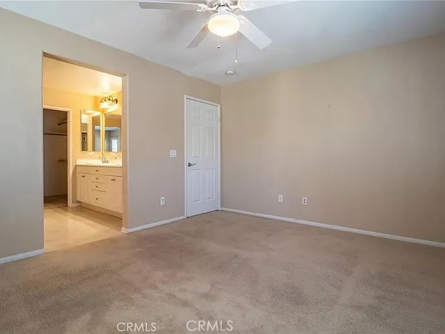 an empty room with closet and a chandelier fan