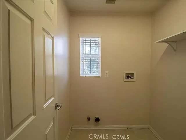 a view of a white house with a small yard and wooden fence