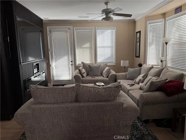 an empty room with chandelier fan and windows