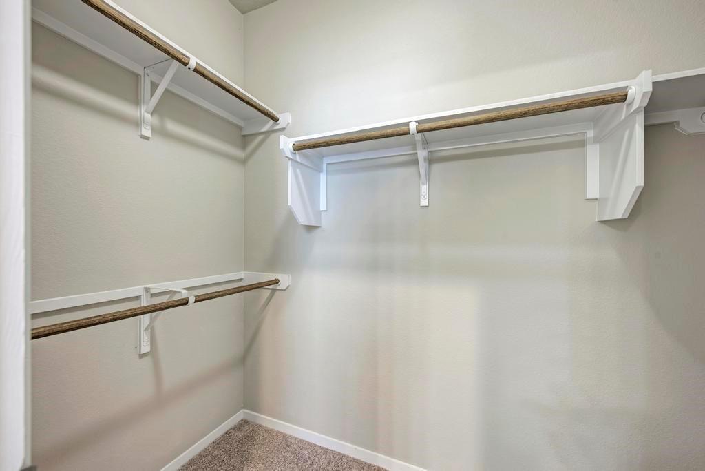 1209 Goforth Road Kyle, TX 78640 - Photo 19 of 32 Custom shelving and hanging rods offer versatile storage in this well-appointed closet.