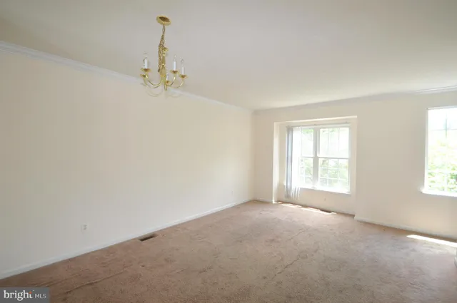 an empty room with a window and a ceiling fan