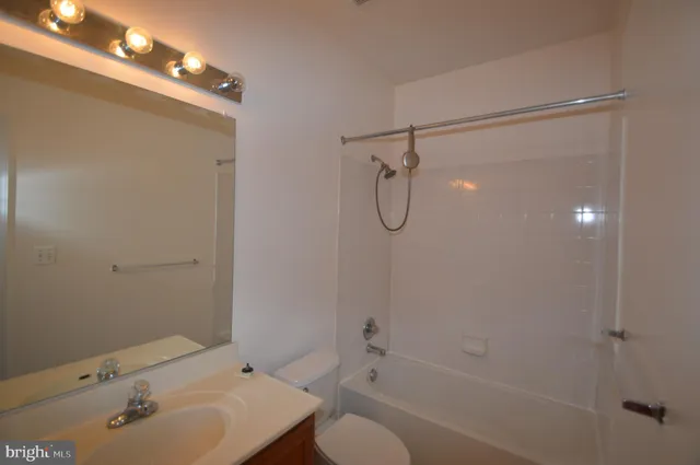 a bathroom with a sink mirror and shower