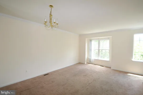 an empty room with a window and a ceiling fan