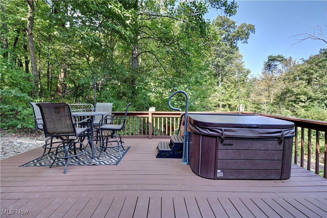 2227 Elk Road Southwest Carrollton, OH 44615 - Photo 25 of 40 Deck with outdoor dining space and a hot tub