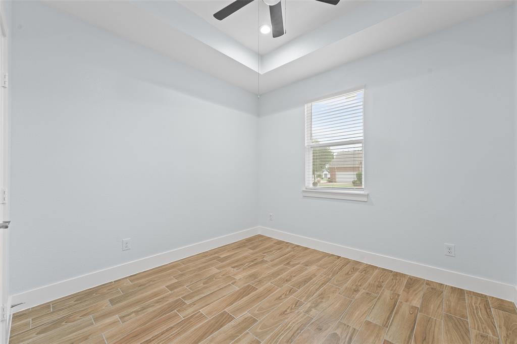 3807 Winding Road Arlington, TX 76016 - Photo 17 of 23 Interior room featuring wood-look tile flooring, light-colored walls, white baseboards, a window with blinds, and a ceiling fan