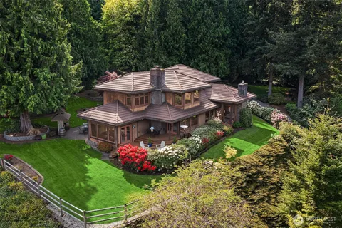 a view of a house with a big yard and large trees
