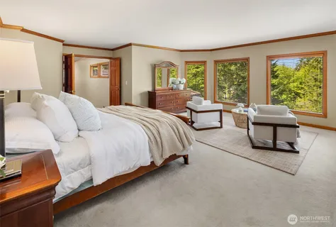 a spacious bedroom with a bed and glass window
