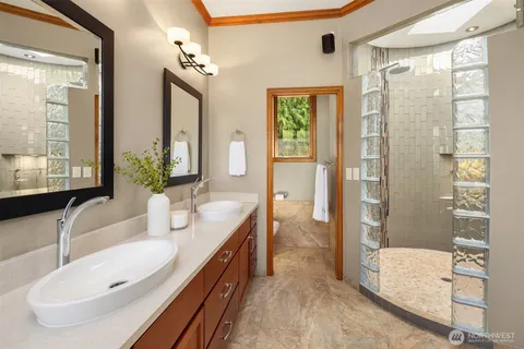 a spacious bathroom with a double vanity sink a mirror and a shower
