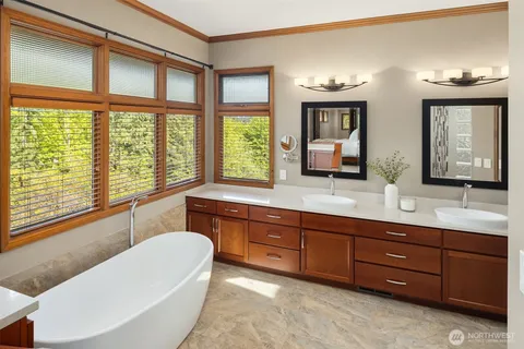 a bathroom with double vanity sinks and a large window