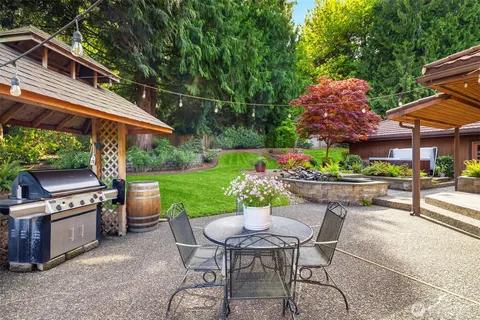 a patio with a table and chairs and potted plants