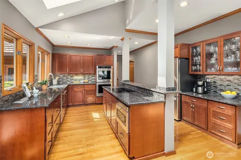 a large kitchen with stainless steel appliances granite countertop a large stove a sink and a refrigerator