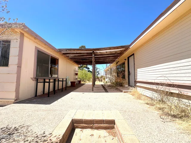 a view of a patio with table and chairs with wooden floor and fence