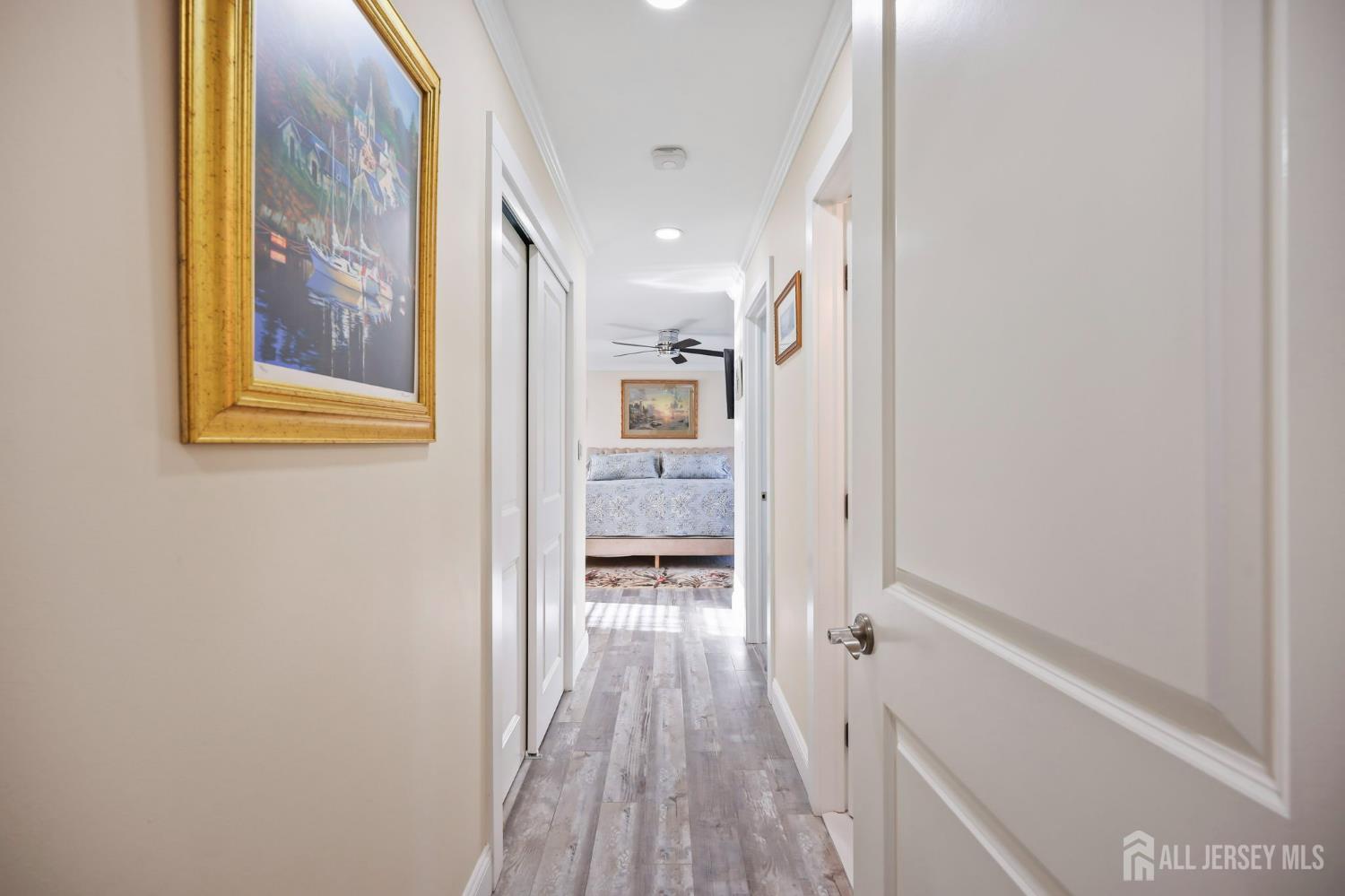 568 Village Road West Windsor, NJ 08550 - Photo 22 of 43 a view of a hallway with wooden floor and a bathroom