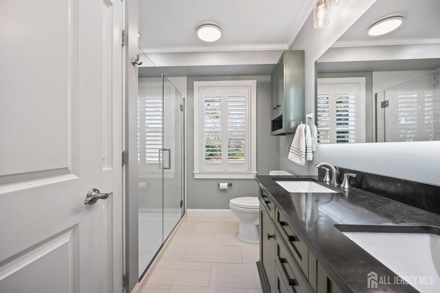 568 Village Road West Windsor, NJ 08550 - Photo 27 of 43 a bathroom with a granite countertop sink a toilet a mirror and window